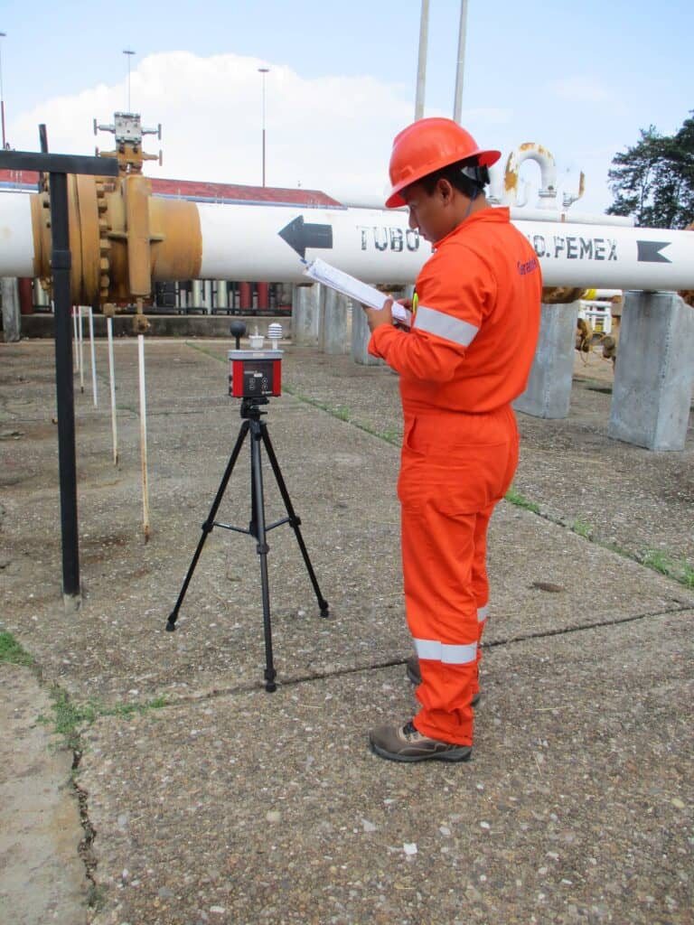 Técnico midiendo niveles de exposición laboral durante estudio de higiene industrial.